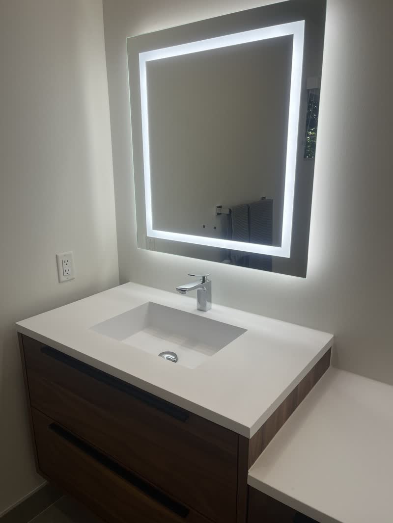 Bathroom vanity and lit mirror after a deep clean